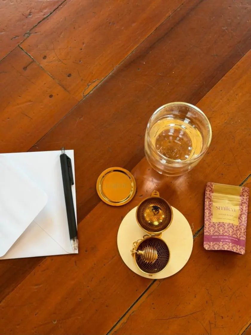 Smitea tea, ritual strainer, intention card and warm tea prepared for an at-home practice